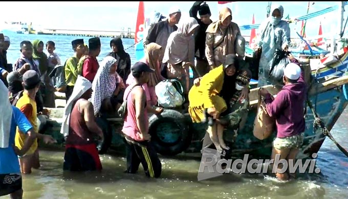 SEGERA BERANGKAT HAJI: Suasana keluarga jamaah haji asal Raas, Sumenep, Madura saat turun dari perahu kayu di Pelabuhan Jangkar, Desa/Kecamatan Jangkar, Selasa (7/6) lalu. (Iwan Feriyanto/Radar Situbondo)