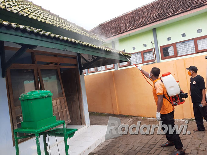 BIKIN RESAH: Petugas BPBD melakukan penyemprotan terhadap ribuan ulat bulu yang ada di Kantor Dispora Situbondo, Senin (13/6) lalu. (Iwan Feriyanto/Radar Situbondo)