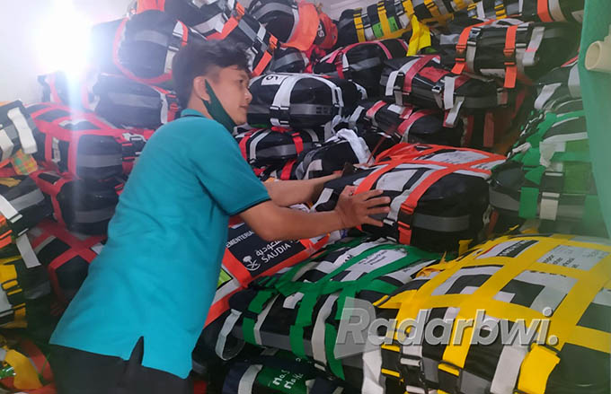 TINGGAL BERANGKAT: Petugas menimbang koper milik jamaah di Kantor Kemenag Situbondo, Jumat (17/6) lalu. (Iwan Feriyanto/Radar Situbondo)