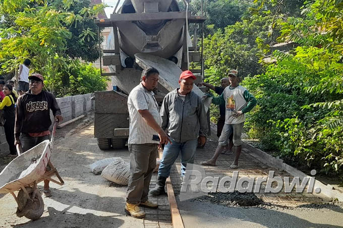 MENUNJUK: Humas tambang CV Lintang Timur Jaya, H Yayan menyuruh tukang untuk bekerja dengan benar agar perbaikan jalan mendapatkan hasil yang bagus, Rabu (8/7). (Humaidi/Radar Situbondo)