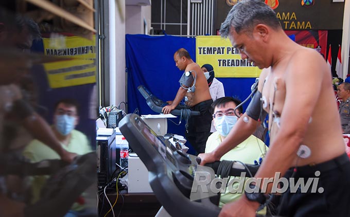 BUKA BAJU: Kapolsek Muncar AKP Imron dan Kasi Humas Polresta Iptu Lita Kurniawan lari di atas treadmill dalam medical check-up, Selasa (7/6). (Ramada Kusuma/Radar Banyuwangi)