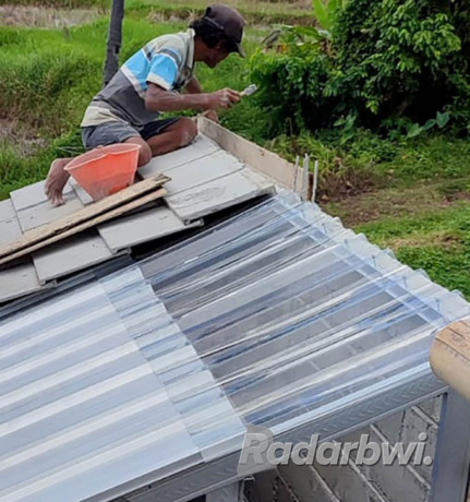 TEMBUS PANDANG: Pekerja memasang atap berbahan fiberglass transparan sehingga cahaya bisa masuk ke ruangan di bawahnya. (Ramada Kusuma/Radar Banyuwangi)