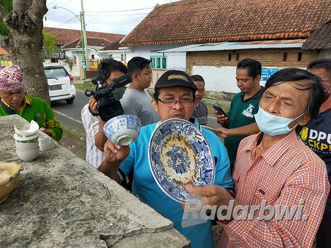 BENDA BERSEJARAH: Tim Ahli Cagar Budaya Kabupaten Banyuwangi (TACB) Ilham Triadi menunjukkan piring Maastricth di Balai Desa Macanputih, Kecamatan Kabat. (Dedy Jumhardiyanto/Radar Banyuwangi)