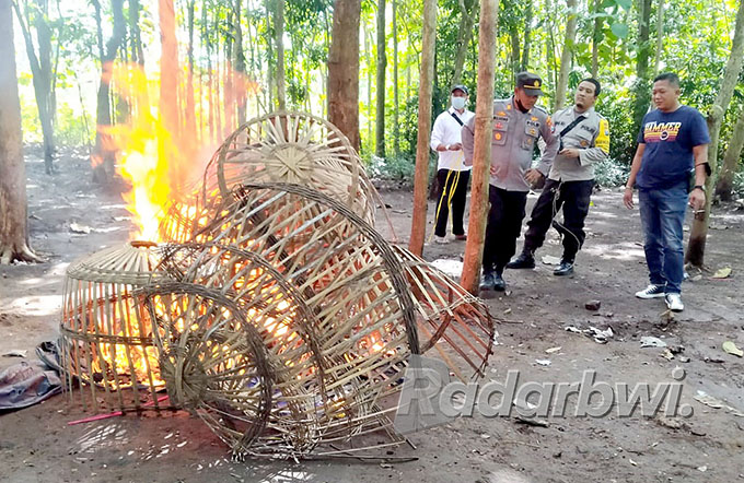HANGUS: Polisi membakar kurungan ayam di Dusun Pasembon, Desa Sambirejo, Kecamatan Bangorejo, Senin (6/6). (Polsek Bangorejo for Radar Genteng)