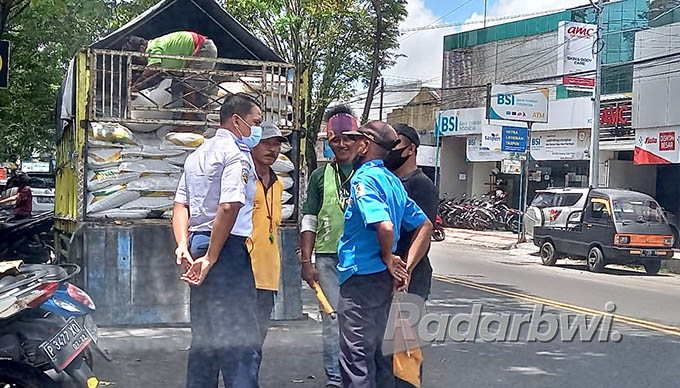PEMBINAAN: Petugas dari Dinas Perhubungan Banyuwangi memberikan teguran kepada tukang parkir liar, di wilayah pasar Genteng 1, Kamis (2/6) lalu. (Irham Muzaki/Radar Genteng)
