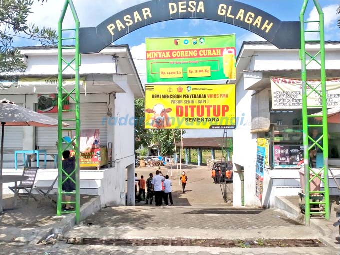 CEGAH PENYEBARAN PMK:  Pintu masuk pasar hewan Glagah dipasang banner bertuliskan ”Ditutup Sementara” kemarin (19/6). (Bagus Rio/RadarBanyuwangi.id)