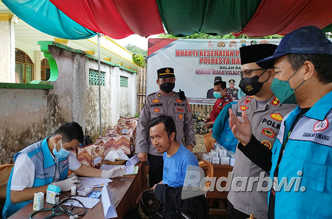 CEK KESEHATAN: Ketua IDI Banyuwangi Yos Hermawan (kanan) bersama Kapolresta Banyuwangi AKBP Deddy Foury Millewa (dua dari kanan) memantau masyarakat yang melakukan pemeriksaan kesehatan di Desa Jelun, Kecamatan Licin, Jumat (23/6) lalu. (Bagus Rio/Radar B