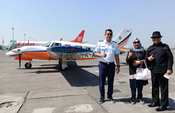 SEBELUM TAKE-OFF: HYH bersama istri Hj Erna Lisa Djohan berpose bersama pilot Capt Biyan Barlian dengan latar belakang pesawat Piper Seneca V di Bandara Banyuwangi, Rabu (22/6). (Sigit Hariyadi/RadarBanyuwangi.id)