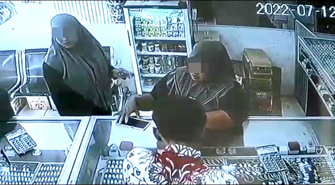 MEMEGANG HP: Perempuan yang diduga mencuri HP milik Rahmawati, warga Dusun Sambian, Desa/Kecamatan Bungatan, di salah satu toko Emas di Dusun Kerajan Desa/Kecamatan Bungatan, Selasa lalu (12/7). (Humaidi/Radar Situbondo)