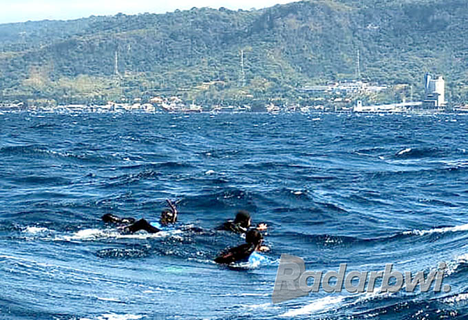 TAKLUKKAN LAUTAN: Dua anggota Kopaska dari Koarmada I Jakarta berenang melintasi Selat Bali, Selasa (19/7). (Ramada Kusuma/Radar Banyuwangi)