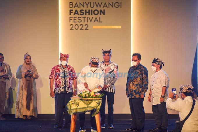 SIMBOL RASA SYUKUR: Wakil Bupati Sugirah menyerahkan potongan tumpeng kepada Staf Ahli Menteri Bidang Ekonomi Makro Dr Rulli Nuryanto dalam pembukaan BFF, tadi malam (12/7).  (Ramada Kusuma/RadarBanyuwangi.id)