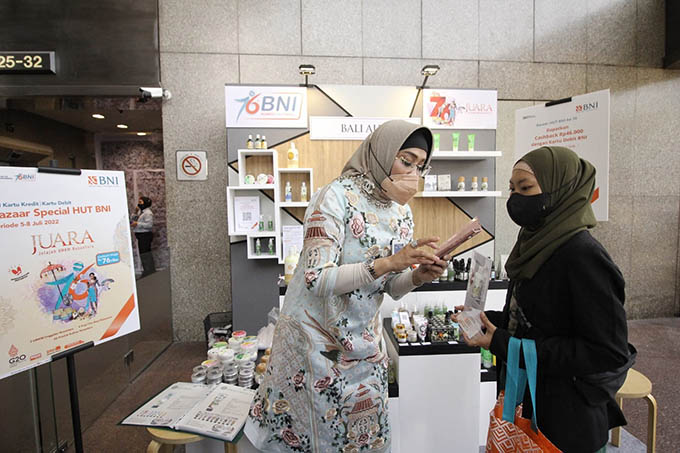 Wakil Direktur Utama BNI Adi Sulistyowati tengah berbelanja sambil meninjau UMKM Binaan BNI pada Bazaar Spesial HUT BNI dengan Tema “Jelajah UMKM Nusantara atau JUARA”, Selasa (5/7/2022). (Humas BNI for Radar Banyuwangi)