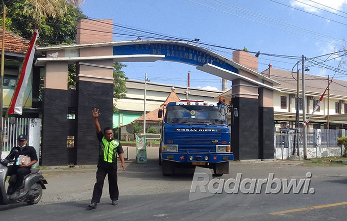JALUR PANTURA: Satpam PG Asembagus mengawal kendaraan roda empat yang baru saja keluar dari gerbang PG Asembagus, Jumat (15/7). (Humaidi/Radar Situbondo)
