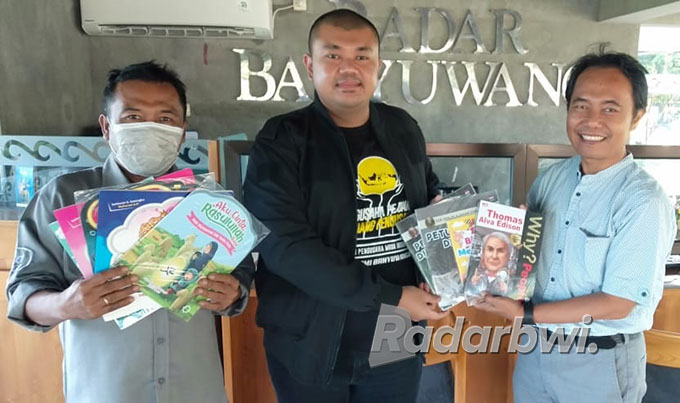 DORONG MINAT BACA: Sekretaris Hipmi Banyuwangi Ferdy Elfian (kiri) menyerahkan buku kepada Direktur JP-RaBa Samsudin Adlawi, Selasa (19/7).   (Toha/Radar Banyuwangi)