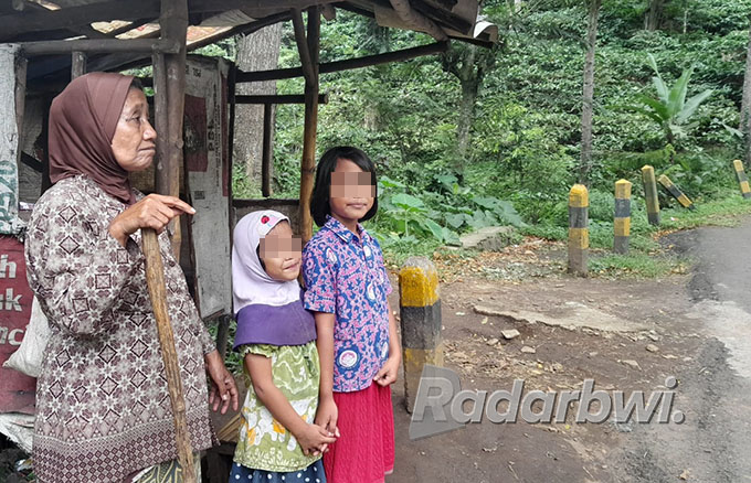 MENUNGGU: Ayu dan Karina bersama neneknya mengarahkan jalan sambil minta sumbangan dari pengendara yang lewat di jalan Gumitir Dusun Barurejo, Desa Kalibaru Manis, Kecamatan Kalibaru, Rabu (6/7). (Irham Muzaki/Radar Genteng)