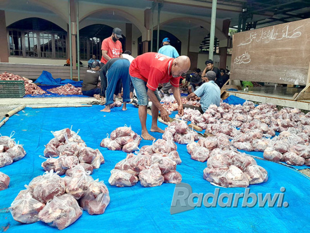 DIBUNGKUS: Panitia pembagian daging kurban di Masjid Baitul Izzah, Dusun Jenisari, Desa Genteng Kulon, Kecamatan Genteng membungkus daging degan tas plastik, Minggu (10/7). (Irham Muzaki/Radar Genteng)