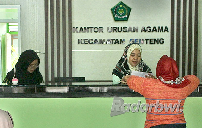 DAFTAR: Salah satu warga di Kecamatan Genteng mengurus persyaratan pernikahan di KUA Genteng, Kamis (21/7). (Salis Ali/Radar Genteng)