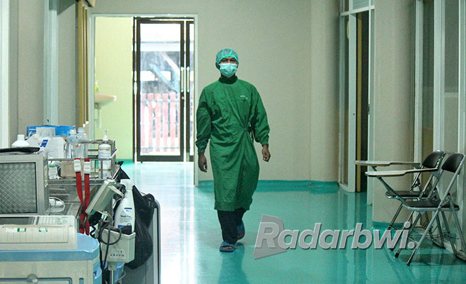 SOP: Kepala Ruangan Isolasi Covid-19 RSUD Genteng Edy Suroso menuju kamar pasien penyintas TBC, Rabu (6/7). (Salis Ali/Radar Genteng)