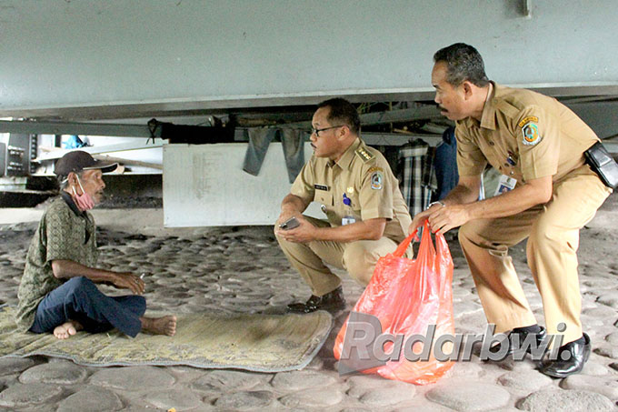PILIH BERTAHAN: Agus Santoso (kiri) ditemui Camat Genteng Satrio (dua dari kanan) di ‘rumahnya’ bawah jembatan Sungai Setail, Desa Genteng Kulon, Kecamatan Genteng, Rabu (6/7). (Salis Ali/Radar Genteng)