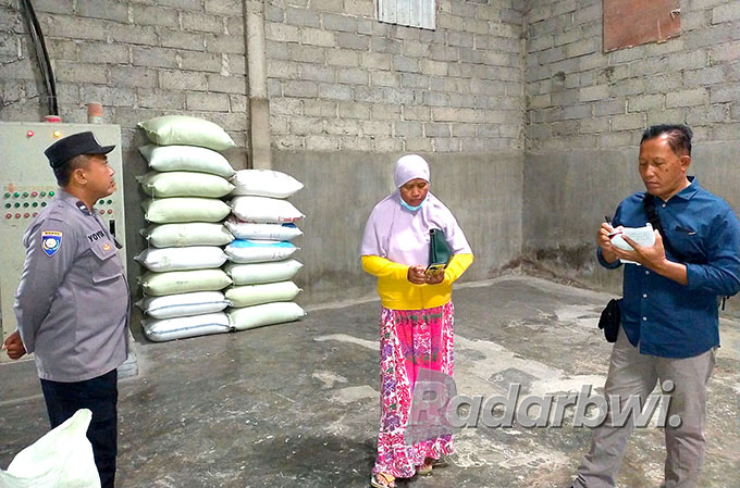 BOLONG: Kanitreskrim Polsek Cluring, Iptu Yaman Adinata (kanan) melihat tembok yang bolong dan diduga dibuat masuk pelaku di selep padi, Dusun Kepatiham, Desa/Kecamatan Cluring, Senin (11/7).  (Polsek Cluring for Radar Genteng)
