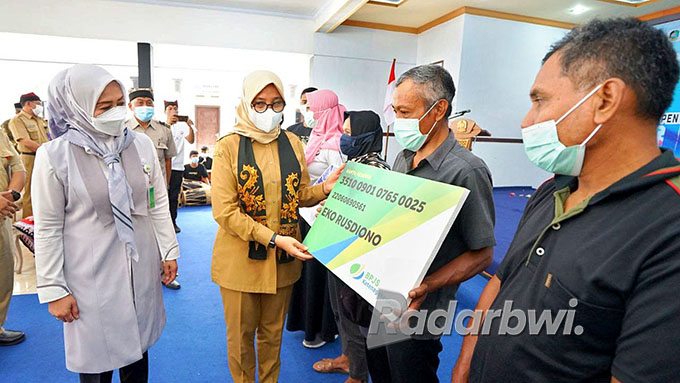 SIMBOLIS: Bupati Ipuk menyerahkan bantuan premi asuransi kepada perwakilan nelayan dalam rangkaian sosialisasi Gemarikan di Desa Kaligondo, Kecamatan Genteng. (Edy for Radar Banyuwangi)