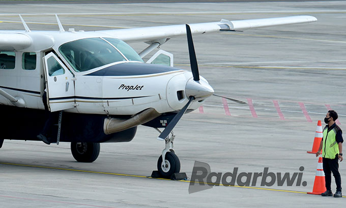 PROPELLER: Petugas memandu pesawat dengan mesin baling-baling di Bandara Banyuwangi. (Ramada Kusuma/Radar Banyuwangi)