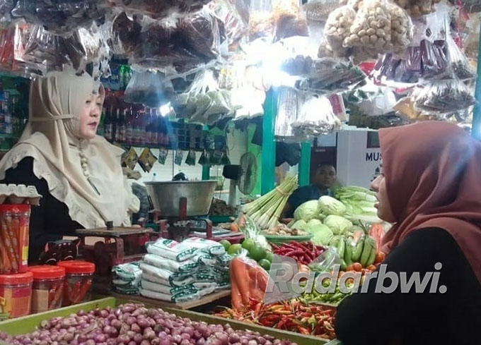 PASAR TRADISONAL SUMBERKOLAK: Salah satu pembeli mengaku mengurangi jumlah kebutuhan telur yang dibeli saat harganya naik, Senin (22/8) lalu. (Iwan Feriyanto/Radar Situbondo)