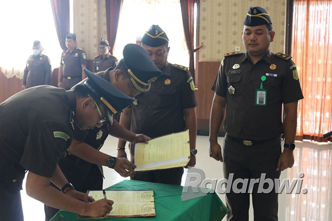 TENAGA BARU: Kasipidsus Kejari Situbondo lama, Reza Aditya Wardhana menandatangani dokumen serah terima jabatan kepada penggantinya, Nyoman Wasita Triantara, Rabu (10/8) lalu. (Humaidi/Radar Situbondo)