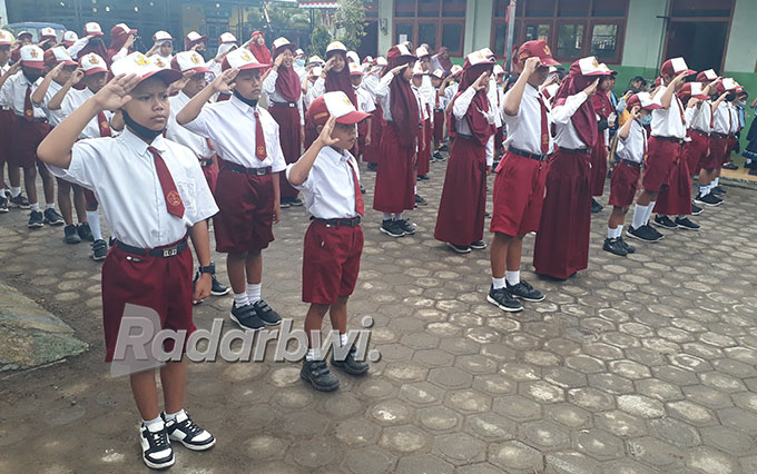 PATUH: Farel Prayoga hormat bendera merah putih dalam upacara di sekolahnya SDN 2 Kepundungan, Kecamatan Srono, Senin (29/8) lalu. (Agus Baihaqi/Radar Genteng)