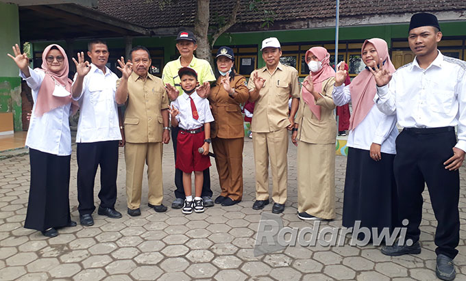BERPISAH: Farel dirangkul guru olahraga yang akan pensiun Sri Wahyudi Suripno, Kepala SDN 2 Kepundungan Ambarwati, dan para guru, Senin (29/8) lalu. (Agus Baihaqi/Radar Genteng)