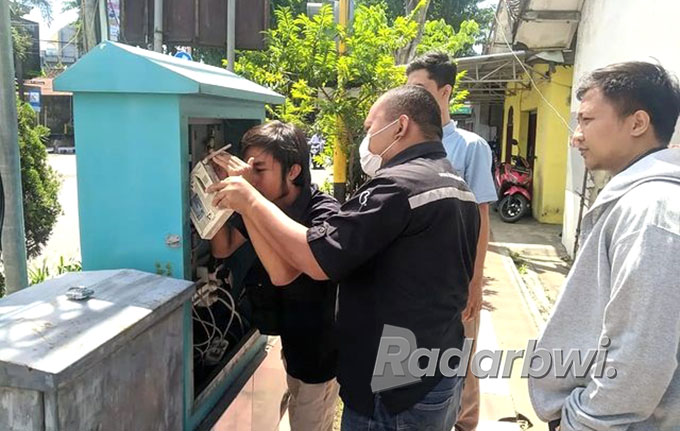 DIPERBAIKI: Petugas Dishub Banyuwangi memperbaiki jaringan CCTV di jalan raya Sukowidi, Kecamatan Kalipuro, Minggu (7/8) siang. (Bagus Rio/Radar Banyuwangi)