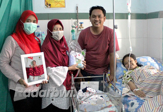 KEMERDEKAAN: Tim medis memberikan kenang-kenangan kepada keluarga Fila Tri yang melahirkan bayinya di RSI Fatimah Banyuwangi pada 17 Agustus 2022. (RSI Fatimah for Radar Banyuwangi)