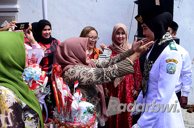 DISAMBUT BAK PAHLAWAN: Ayumi Putri Sasaki mendapatkan ucapan selamat dari komunitas sosial ibu-ibu setelah tiba di rumahnya Jalan Rinjani 29, Kelurahan Singotrunan, Selasa (30/8). (Ramada Kusuma/Radar Banyuwangi)