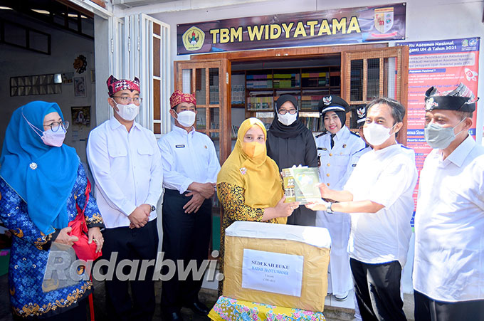 SERAH TERIMA: Direktur Jawa Pos Radar Banyuwangi Samsudin Adlawi menyerahkan seratus judul buku kepada pengelola PKBM Widyatama Kuntiyati, Rabu (17/8). (Ramada Kusuma/Radar Banyuwangi)
