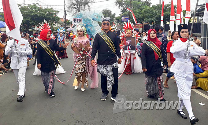 NASIONALISME: Guru dan siswa MTsN 5 Banyuwangi dalam kiran budaya di Desa/Kecamatan Cluring pada Sabtu siang (27/8). (Agus Baihaqi/Radar Genteng)