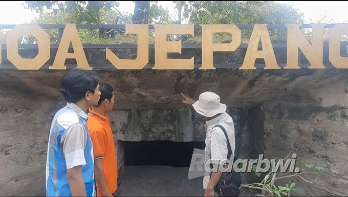 BANGUNAN TUA: Siyanto menceritakan sejarah bangunan goa Jepang kepada dua orang pengunjung di Taman Nasional Baluran Situbondo, Desa Sumberwaru, Kecamatan Banyuputih, Jumat (12/8) lalu. (Iwan Feriyanto/Radar Situbondo)