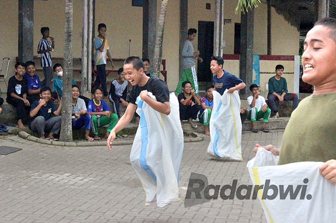LOMBA AGUSTUSAN: Santri SMP Daarul Qur’an Singojuruh tampak semangat mengikuti lomba balap karung. (Daqu for Radar Banyuwangi)