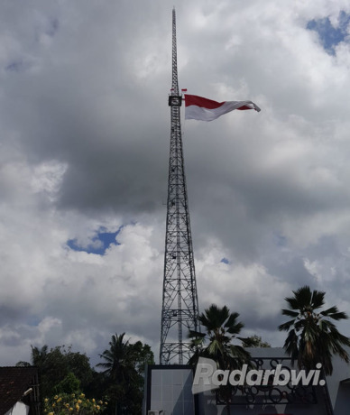 TINGGI: Bendera Merah Putih raksasa berkibar di tower TBT Dusun Glowong, Desa Wringinagung, Kecamatan Gambiran, Selasa (30/8). (Irham Muzaki/Radar Genteng)