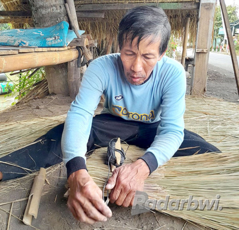 TERSUSUN: Saeroji membuat atap dari rumput ilalang di Dusun Sumberkembang, Desa Karangmulyo, Kecamatan Tegalsari, Senin (8/8) lalu. (Irham Muzaki/Radar Genteng)