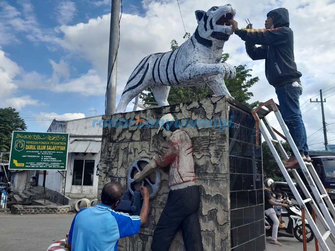 LEBIH INDAH: Tugu Macan di jalan simpang lima Dusun Sumberejo, Desa Jajag, Kecamatan Gambiran dicat ulang, kemarin (11/8). (Muzaki/RadarBanyuwangi.id)