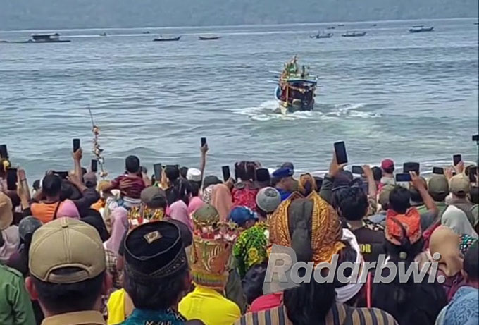 RAMAI: Warga melarung sesaji yang dinaikkan perahu kecil di Pantai Rajegwesi, Dusun Krajan, Desa Sarongan, Kecamatan Pesanggaran, Selasa (2/8). (Polsek Pesanggaran for Radar Genteng)