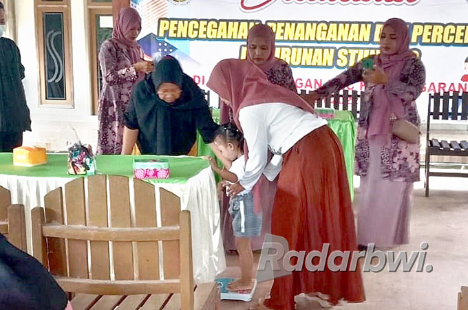 FOKUS: Ibu menimbang anaknya dalam sosialisasi pencegahan stunting di kantor Desa Sarongan, Kecamatan Pesanggaran, Rabu (27/7) lalu. (Gilang for Radar Genteng)