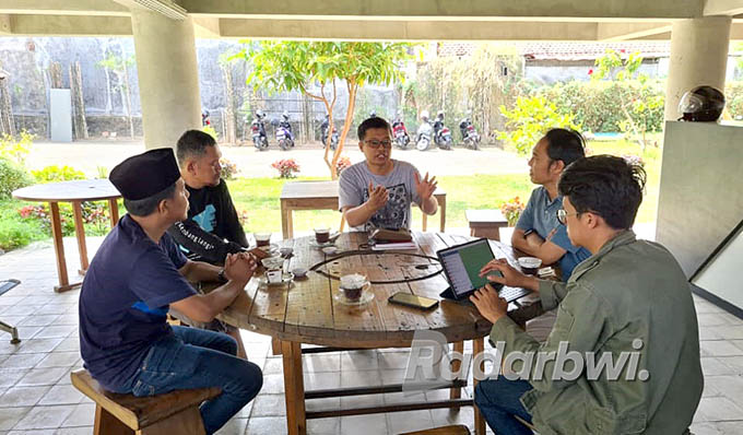 MINTA MASUKAN: Kurator I Wayan Seriyoga Parta menyampaikan pandangannya dalam rapat kecil membahas persiapan pameran ArtOs Nusantara di kantor Radar Banyuwangi, Selasa (2/8). (Syaifuddin Mahmud/Radar Banyuwangi)