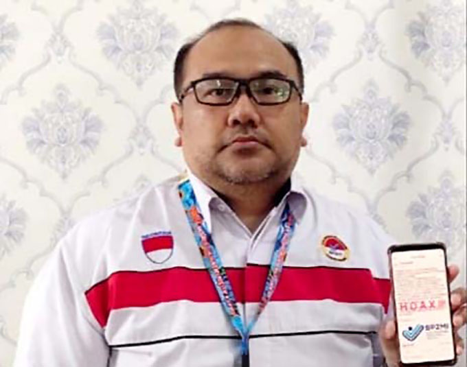 HOAKS: Ketua BP2MI Muhammad Iqbal menunjukkan akun media sosial yang menyebarkan berita bohong saat ditemui di kantor BP2MI Banyuwangi, Senin (15/8) lalu. (Bagus Rio/Radar Banyuwangi)