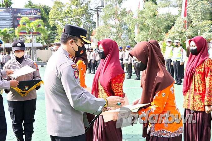 APRESIASI: Kapolresta Banyuwangi Kombespol Deddy Foury Millewa (kiri) memberikan penghargaan kepada para anggota Sanggar Tari Sayu Wiwit di halaman Polresta Banyuwangi, Senin (22/8) lalu. (Bagus Rio/Radar Banyuwangi)