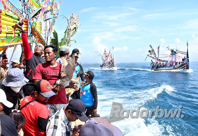 TENGAH LAUT: Nelayan Muncar dengan naik kapal slerek membawa gitik berisi sesaji berupa hasil bumi dan laut ke Semenanjung Sembulungan pada Sabtu (13/8) lalu. (Salis Ali/Radar Genteng)