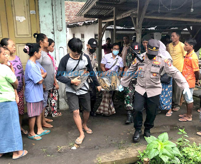 EVAKUASI: Kapolsek Srono AKP Achmad Junaidi bersama warga mengangkat mayat Nur Wahid menuju mobil ambulans Puskesmas Wonosobo untuk dibawa ke RSUD Genteng, kemarin (22/8).(Salis Ali/RadarBanyuwangi.id)