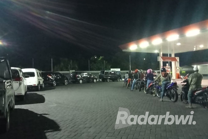 MENGULAR: Pengendara roda dua dan roda empat menunggu antrean di SPBU Karangasem, Rabu (31/8) malam. (Humaidi/Radar Situbondo)