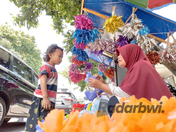 PENASARAN: Seorang bocah mengamati pedagang yang sedang membuat kembang endog di Pasar Banyuwangi, Senin (26/9). (Abdul Adim/Radar Banyuwangi)