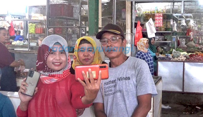 TONTONAN: Pedagang di Pasar Srono, Desa Kebaman, Kecamatan Srono menonton penampilan Farel Prayoga di HP, kemarin (31/8). (Salis Ali/RadarBanyuwangi.id)
